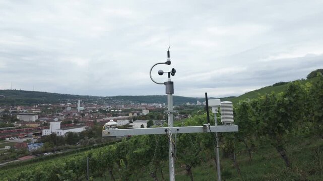 Weather station with cup anemometer, wind vane, thermometer and humidity sensor on a vineyard. Smart farming technology, measuring meteorological conditions. Air quality and climate monitoring.