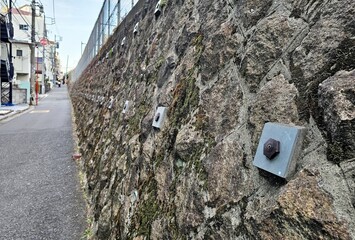 Square plates and bolts visible are structural anchors designed to stabilize the wall and prevent landslides.