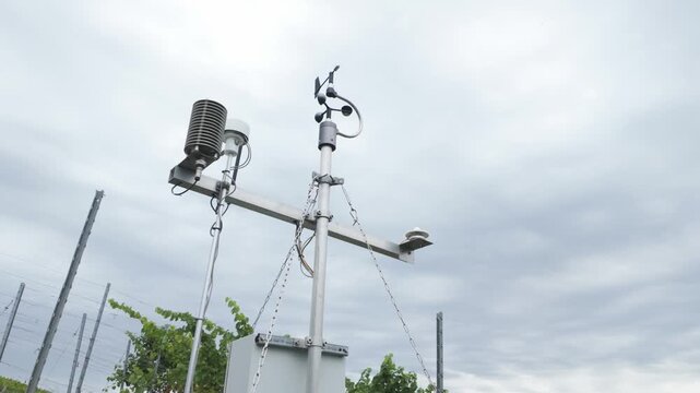Weather station with cup anemometer, wind vane, thermometer and humidity sensor on a vineyard. Smart farming technology, measuring meteorological conditions. Air quality and climate monitoring.