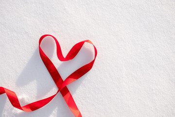 Red ribbon heart shape on snow background romantic winter love symbol valentine holiday minimal concept with copy space