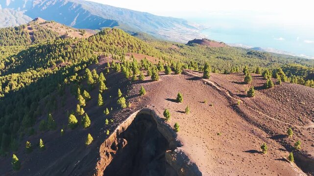 Aerial drone footage flying over volcanic crater toward caldera ridge in La Palma