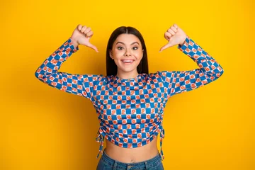 Fotobehang Onderzeeër Young Latina woman smiles brightly wearing a checkered blue and white top posing against a vibrant yellow background expressing joy fashion style and confidence  © deagreez