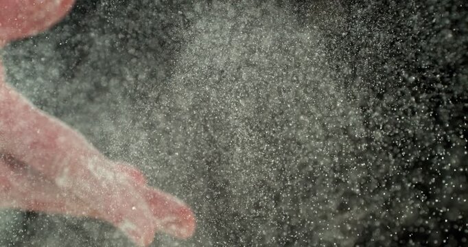 Super slow motion, 1000 fps. Close-up of baker&rsquo;s hand tossing flour over prepared risen dough on wooden table. Cinematic baking concept, artisan bread preparation and texture detail. Speed ramp effect