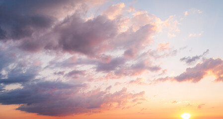 Dramatic clouds with sun rays breaking through sunset sky