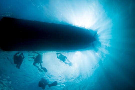 A group of divers returns to the boat after a dive.