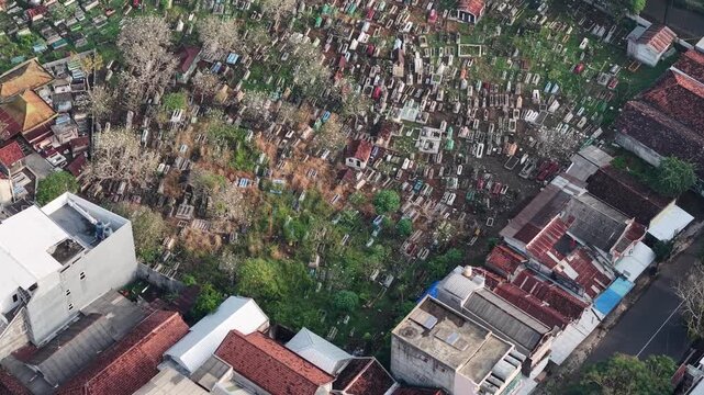 Aerial View Of Dense Cemetery And Rooftop Urban Neighborhood From Above