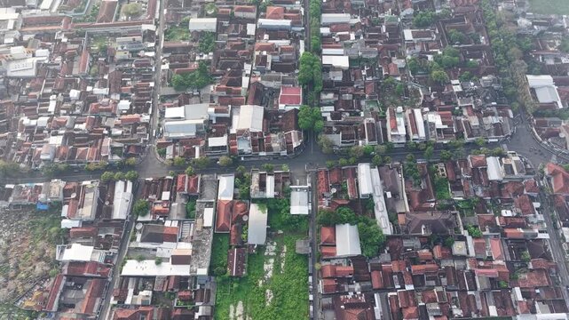 Aerial View Of Dense Urban Neighborhood With Green Patches And Red Tile Roofs