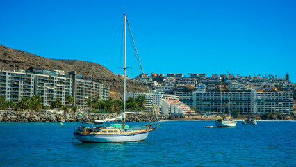 White sailing yacht anchored in the blue waters of a resort bay © Андрей Нелупов