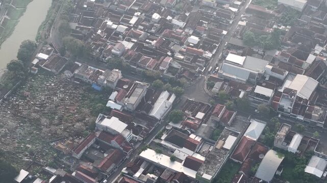 Aerial View Over Dense Town With Cemetery And River In The City