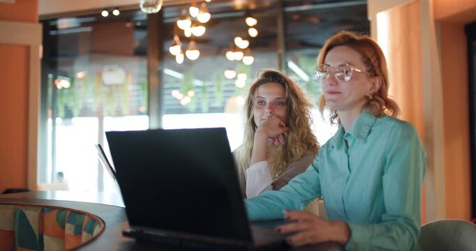 Businesswomen collaborate in a modern workspace while discussing strategies and ideas in a vibrant setting