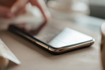 An image featuring a user&rsquo;s hand about to touch a smartphone screen, symbolizing interaction in a digital world, connections, and the seamless blend of technology into our lives.