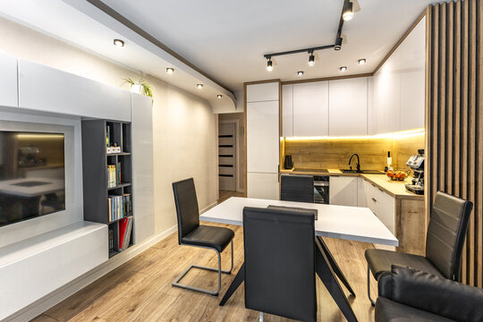 Modern built-in kitchen furniture, furniture with white high-gloss painted fronts, modern living room with kitchenette, apartment renovation, functional kitchen furniture with oven, induction hob, cof