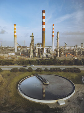 Aerial view of the industrial landscape with towering chimneys and circular tanks under a blue sky, a contrast of human engineering and natural elements, Matosinhos, Porto District, Portugal.
