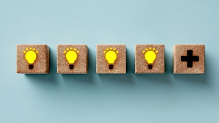 Four wooden blocks aligned with three featuring bright yellow lightbulb symbols and one with a black plus sign,