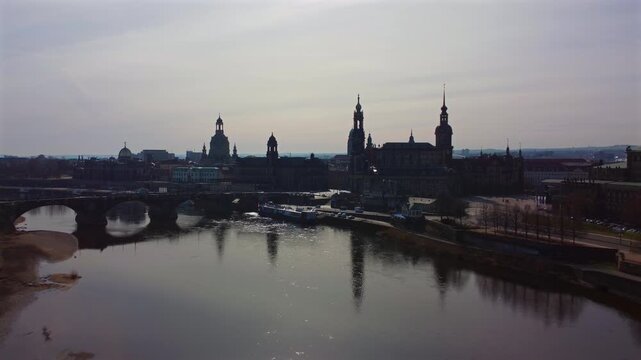 Cinematic silhouette of Dresden&rsquo;s historic Altstadt along the Elbe River. Featuring the iconic Frauenkirche dome, Hofkirche cathedral, and Royal Palace spire against a vibrant golden hour sky.