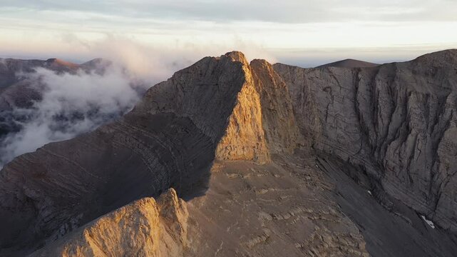Sunset light aerial pullback from Throne of Zeus cliffs above Plateau of Muses Mount Olympus Greece