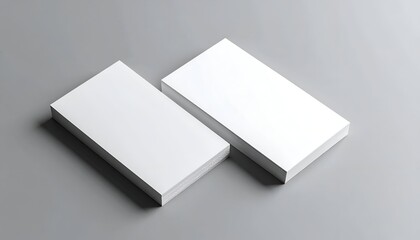 Two stacks of blank white cards on a gray surface, slightly overlapping