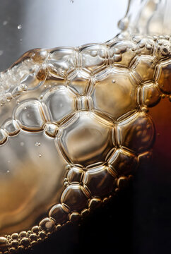 Craft beer foam head macro with golden bubbles and amber texture