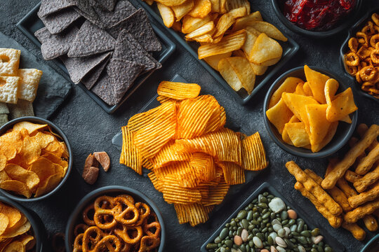 A variety of colorful snacks arranged on a dark surface