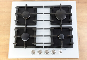 White built-in gas hob with 4 burners made of tempered glass.