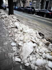 Snow Pile Along City Street Sidewalk After Freeze, Quiet Urban Scene With Parked Cars