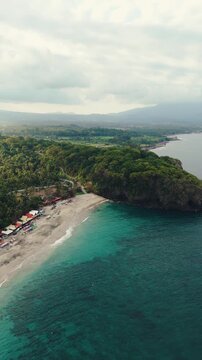 4K drone video flying away from Song Lambung Beach in Nusa Lembongan near Bali in Indonesia. This stunning white sand beach is a popular spot for tourists looking to relax and surf.
