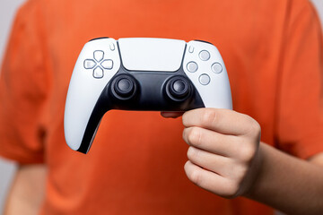 Gamer hand using video game console controller. Playing games concept. Close up of child hands playing the video game. Child holding a game controller. Woman with game controller, closeup © Yevhen