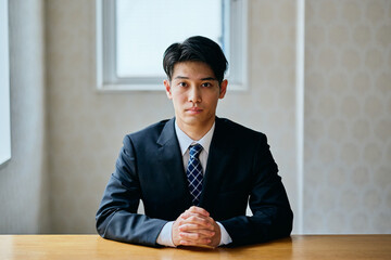Businessman sitting at desk during meeting or online conversation in office
