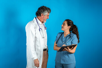 Doctor and nurse interacting, discussing patient data on a tablet. Healthcare team working together on a medical record