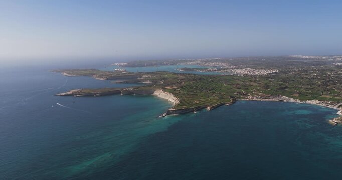 Aerial view of the rugged Munxar Path coastline with its turquoise waters contrasting against the white cliffs, Marsaskala, Malta.