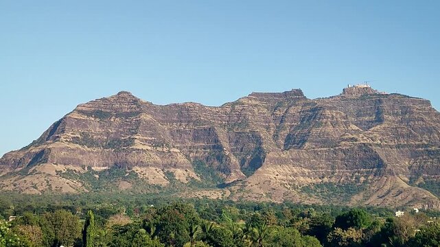 Pavagadh hill in Panchmahal Gujarat India showing rocky mountain landscape with green forest under clear blue sky.