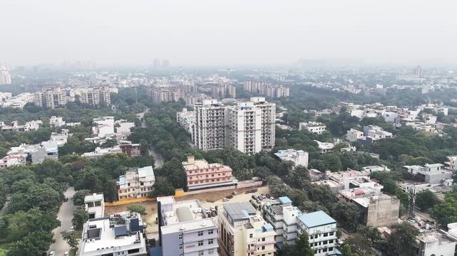 A wide drone view captures Greater Noida&rsquo;s planned grid&mdash;lush greens, low-rise homes, and distant high-rises fading into pollution-tinted horizons.