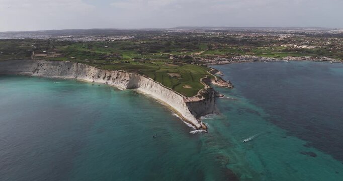 Aerial view of the dramatic white cliffs meeting the turquoise waters along the Munxar Path coastline creating a stunning contrast, Munxar Path, Marsaskala, Malta.