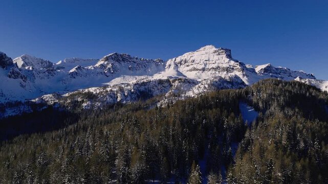 Snow-capped Peaks Rise Above Arabba in the Dolomites, Veneto&ndash;Trentino-Alto Adige, Italy - Orbit Drone Shot