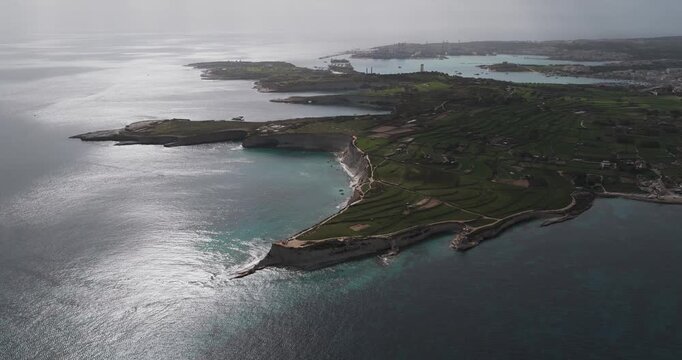 Aerial view of the rugged coastline meeting the vast ocean, creating a mesmerizing contrast of textures and tones, Munxar Path, Marsaskala, Malta.