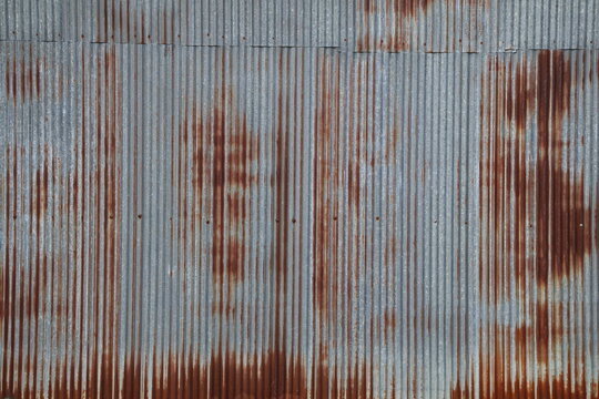 Artistic of old and rusty zinc sheet wall. Vintage style metal sheet roof texture. Pattern of old metal sheet. Rusting metal or siding. Corrosion of galvanized. Background and texture in retro concept