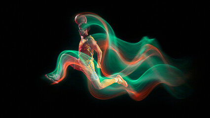 Bright artwork. Basketball player in mid air slam dunk with light trails on dark background....
