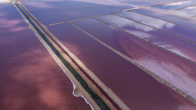 Aerial view of pink salt ponds create a surreal landscape with striking geometric patterns and contrasting hues, Yallabatharra, Western Australia, Australia.