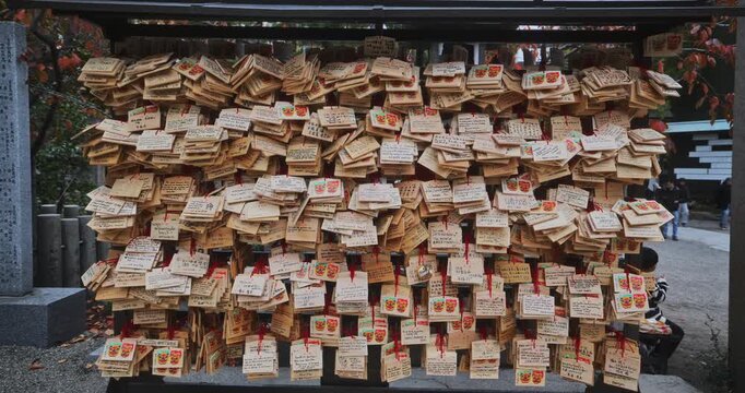 Smooth steady cam in on wooden objects on wall at Japanese shrine