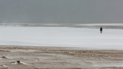 Spaziergang am Strand im Wintersturm an der Nordsee auf Borkum