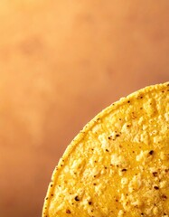Close Up Of A Golden Corn Tortilla Chip Against A Warm Textured Background With Soft Lighting