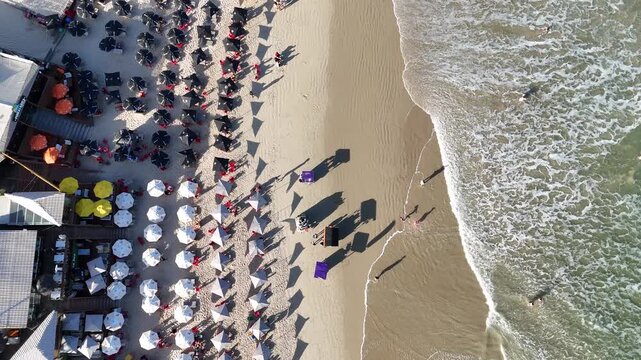 Belebter Traumstrand in Florian&oacute;polis mit Sonnenschirmen und klarem Meer