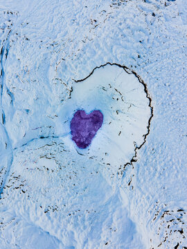 Aerial view of a heart-shaped hot spring surrounded by a snowy landscape, Thermal springs, Hveragersisbaer, Iceland.