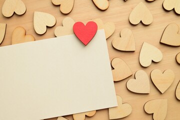 Valentine's Day celebration. Blank card and wooden hearts on a wooden background 