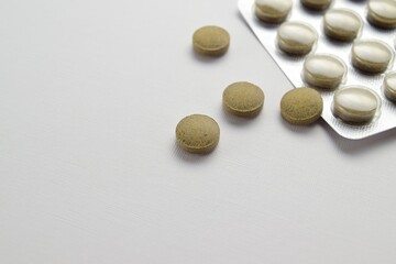 Herbal tablets in blister pack on light background