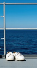 Obraz premium Bright summer day on a naval vessel deck. White maritime footwear resting near polished railing with clear blue ocean background ,classic ,shore ,deck