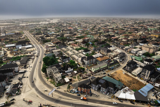 Aerial view of a winding road cutting through a dense urban landscape under a moody sky, Didi Mc Close, Port Harcourt, Rivers, Nigeria.