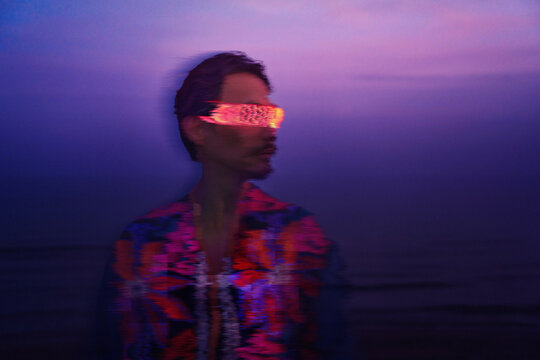 Person wearing VR glasses with cyberpunk glitch effect at night