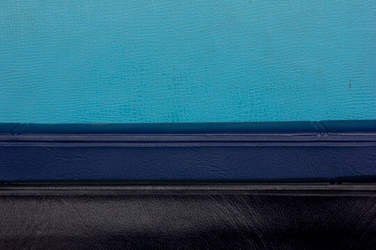 Close-up full frame photo of a stack of black and blue-covered Bibles, copy space background and texture.