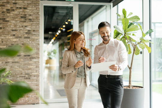 Colleagues discussing work documents in modern office interior